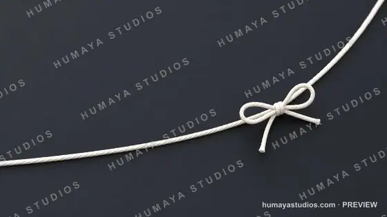 White Cord Tied in a Neat Bow on Dark Background